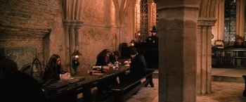 Movie still from “Harry Potter and the Chamber of Secrets” (2002), directed by Chris Columbus – A group of people sitting at a table in a room; Wide shot, High angle