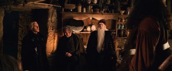 Movie still from “Harry Potter and the Chamber of Secrets” (2002), directed by Chris Columbus – Two men dressed in medieval garb in front of a shelf; Medium shot, High angle