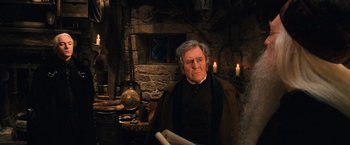 Movie still from “Harry Potter and the Chamber of Secrets” (2002), directed by Chris Columbus – An older man in a dark room with a candle; Medium shot, Low angle