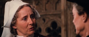 Movie still from “Harry Potter and the Chamber of Secrets” (2002), directed by Chris Columbus – An older woman wearing a white hat looking at the camera; Close Up shot, Over the shoulder angle