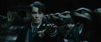 Movie still from “Harry Potter and the Chamber of Secrets” (2002), directed by Chris Columbus – A young man in a harry potter uniform is holding out his hand; Close Up shot, High angle