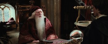 Movie still from “Harry Potter and the Chamber of Secrets” (2002), directed by Chris Columbus – An old man dressed as dumbledore sitting at a table; Medium shot, Over the shoulder angle