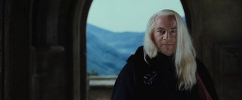 Movie still from “Harry Potter and the Chamber of Secrets” (2002), directed by Chris Columbus – A man with white hair is standing in front of a window; Close Up shot, Over the shoulder angle