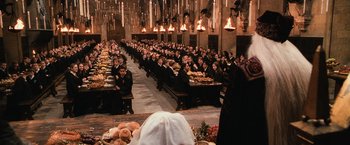 Movie still from “Harry Potter and the Chamber of Secrets” (2002), directed by Chris Columbus – A group of people sitting at a long table with food; Extreme Wide shot, High angle