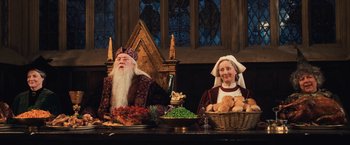 Movie still from “Harry Potter and the Chamber of Secrets” (2002), directed by Chris Columbus – A man and a woman sitting at a table with food; Medium shot, High angle