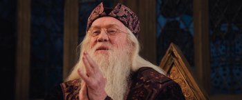Movie still from “Harry Potter and the Chamber of Secrets” (2002), directed by Chris Columbus – An old man with long white hair wearing a purple hat; Close Up shot, Low angle