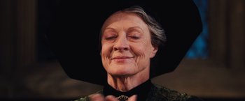 Movie still from “Harry Potter and the Chamber of Secrets” (2002), directed by Chris Columbus – An older woman wearing a black hat and a green jacket; Close Up shot, Low angle