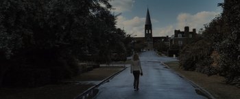Movie still from “Harry Potter and the Deathly Hallows: Part 1” (2010), directed by David Yates – A woman walking down a street with a church in the background; Extreme Wide shot, High angle