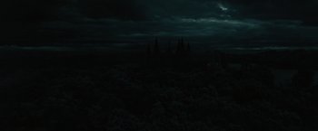 Movie still from “Harry Potter and the Deathly Hallows: Part 1” (2010), directed by David Yates – A view of a dark sky with a castle in the background; Extreme Wide shot, High angle