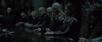 Movie still from “Harry Potter and the Deathly Hallows: Part 1” (2010), directed by David Yates – A group of people sitting around a table; Medium shot, High angle