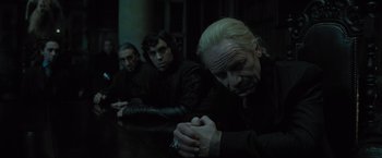 Movie still from “Harry Potter and the Deathly Hallows: Part 1” (2010), directed by David Yates – A group of people sitting at a table; Medium shot, Low angle
