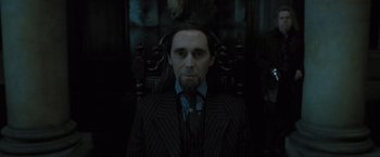 Movie still from “Harry Potter and the Deathly Hallows: Part 1” (2010), directed by David Yates – A man in a suit and tie sitting in a chair; Close Up shot, Low angle