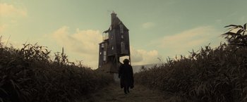 Movie still from “Harry Potter and the Deathly Hallows: Part 1” (2010), directed by David Yates – A person standing in front of an old house; Extreme Wide shot, Low angle
