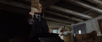 Movie still from “Harry Potter and the Deathly Hallows: Part 1” (2010), directed by David Yates – A man in a suit and tie holding a paper bag; Medium shot, Low angle