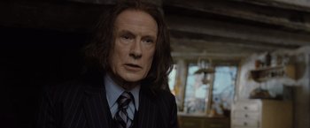 Movie still from “Harry Potter and the Deathly Hallows: Part 1” (2010), directed by David Yates – A person wearing a suit and tie; Close Up shot, Over the shoulder angle