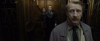 Movie still from “Harry Potter and the Deathly Hallows: Part 1” (2010), directed by David Yates – A man and a woman standing in an elevator; Medium shot, Low angle