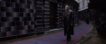Movie still from “Harry Potter and the Deathly Hallows: Part 1” (2010), directed by David Yates – A man in a long black leather coat walking down the street; Wide shot, Low angle