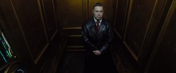 Movie still from “Harry Potter and the Deathly Hallows: Part 1” (2010), directed by David Yates – A man wearing a leather jacket standing in an elevator; Medium shot, Low angle