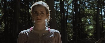 Movie still from “Harry Potter and the Deathly Hallows: Part 1” (2010), directed by David Yates – A woman standing in front of a tree in the woods; Close Up shot, Low angle