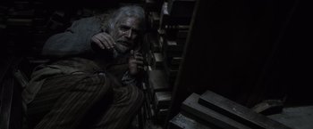 Movie still from “Harry Potter and the Deathly Hallows: Part 1” (2010), directed by David Yates – An old man sitting in a dark room; Medium shot, Overhead angle