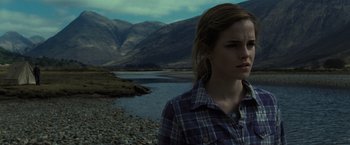 Movie still from “Harry Potter and the Deathly Hallows: Part 1” (2010), directed by David Yates – A woman standing in front of a body of water and mountains; Close Up shot, Low angle