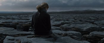 Movie still from “Harry Potter and the Deathly Hallows: Part 1” (2010), directed by David Yates – A woman sitting on top of a rock formation; Wide shot, High angle