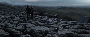 Movie still from “Harry Potter and the Deathly Hallows: Part 1” (2010), directed by David Yates – Two people standing on top of a rocky cliff; Extreme Wide shot, High angle
