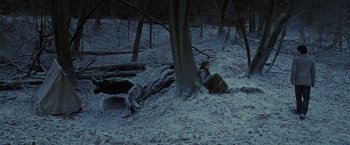 Movie still from “Harry Potter and the Deathly Hallows: Part 1” (2010), directed by David Yates – A person sitting on the ground under a tree in the snow; Wide shot, High angle