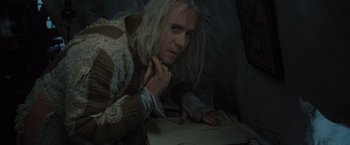 Movie still from “Harry Potter and the Deathly Hallows: Part 1” (2010), directed by David Yates – A man with long white hair is looking at a piece of paper; Close Up shot, High angle