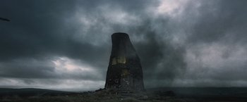 Movie still from “Harry Potter and the Deathly Hallows: Part 1” (2010), directed by David Yates – A tall tower in the middle of a field with dark clouds above it; Extreme Wide shot, Low angle