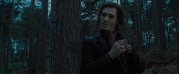 Movie still from “Harry Potter and the Deathly Hallows: Part 1” (2010), directed by David Yates – A man in a leather jacket standing next to a tree; Close Up shot, Over the shoulder angle