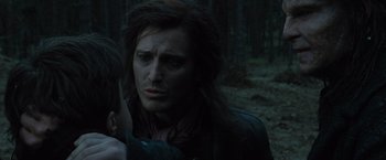 Movie still from “Harry Potter and the Deathly Hallows: Part 1” (2010), directed by David Yates – A man with long dark hair is in the woods; Close Up shot, Over the shoulder angle