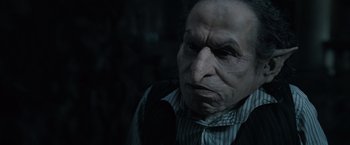 Movie still from “Harry Potter and the Deathly Hallows: Part 1” (2010), directed by David Yates – An old man in a striped shirt is looking at the camera; Close Up shot, Low angle