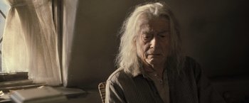 Movie still from “Harry Potter and the Deathly Hallows: Part 2” (2011), directed by David Yates – An old man with long white hair sitting in a chair; Close Up shot, Low angle
