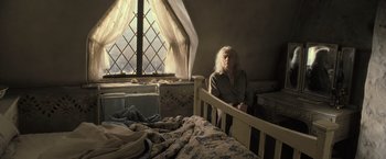 Movie still from “Harry Potter and the Deathly Hallows: Part 2” (2011), directed by David Yates – An old woman sitting in a bed in front of a window; Medium shot, High angle
