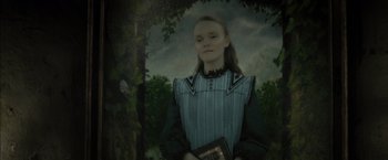 Movie still from “Harry Potter and the Deathly Hallows: Part 2” (2011), directed by David Yates – A woman holding a book standing in front of a tree; Medium shot, Low angle