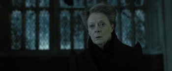 Movie still from “Harry Potter and the Deathly Hallows: Part 2” (2011), directed by David Yates – An older woman in a black coat looking at the camera; Close Up shot, Low angle