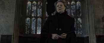 Movie still from “Harry Potter and the Deathly Hallows: Part 2” (2011), directed by David Yates – An older woman holding a wand in front of stained glass windows; Close Up shot, Low angle