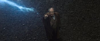 Movie still from “Harry Potter and the Deathly Hallows: Part 2” (2011), directed by David Yates – An old man in a brown coat pointing at the camera; Medium shot, Overhead angle