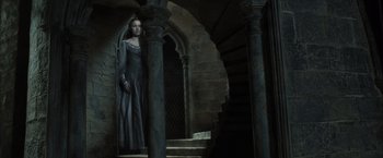Movie still from “Harry Potter and the Deathly Hallows: Part 2” (2011), directed by David Yates – A woman standing in front of a spiral stair case; Wide shot, Low angle