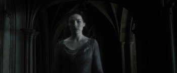 Movie still from “Harry Potter and the Deathly Hallows: Part 2” (2011), directed by David Yates – A woman standing in front of an archway in a dark room; Medium shot, Low angle
