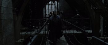 Movie still from “Harry Potter and the Deathly Hallows: Part 2” (2011), directed by David Yates – A group of people walking across a bridge at night; Wide shot, Low angle