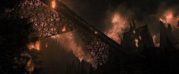 Movie still from “Harry Potter and the Deathly Hallows: Part 2” (2011), directed by David Yates – A fire is burning in the mountains near a bridge; Extreme Wide shot, Low angle
