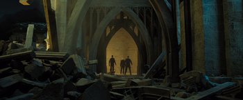 Movie still from “Harry Potter and the Deathly Hallows: Part 2” (2011), directed by David Yates – A group of people standing inside of a building; Wide shot, Low angle