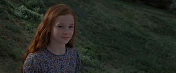 Movie still from “Harry Potter and the Deathly Hallows: Part 2” (2011), directed by David Yates – A young girl with red hair is smiling for the camera; Close Up shot, High angle