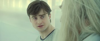 Movie still from “Harry Potter and the Deathly Hallows: Part 2” (2011), directed by David Yates – A young man looking into a mirror while standing next to a woman; Close Up shot, Over the shoulder angle