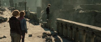 Movie still from “Harry Potter and the Deathly Hallows: Part 2” (2011), directed by David Yates – A man standing on top of a stone pillar; Wide shot, High angle