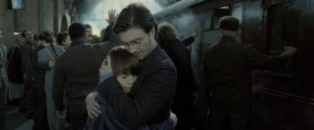 Movie still from “Harry Potter and the Deathly Hallows: Part 2” (2011), directed by David Yates – A man and a boy hugging in a train station; Medium shot, Low angle