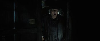 Movie still from “Harry Potter and the Goblet of Fire” (2005), directed by Mike Newell – An old man standing in the dark in a dark room; Medium shot, Low angle