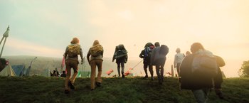 Movie still from “Harry Potter and the Goblet of Fire” (2005), directed by Mike Newell – A group of people walking up a grassy hill; Wide shot, Low angle